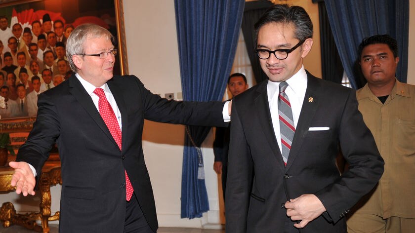 Kevin Rudd gestures as he walks next to the Indonesian foreign minister