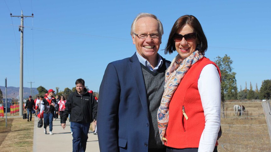 Peter Beattie and his wife pose on the street among the crowds heading toward a rugby game.