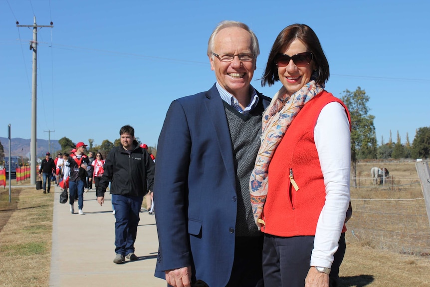 Peter Beattie and his wife pose on the street among the crowds heading toward a rugby game.