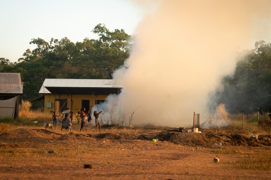 Smoke billows fom the ground into the sky from a front-yard fire Wadeye.