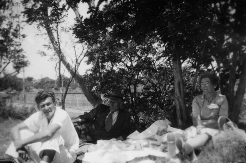 bob with parents on a picnic rug in a park