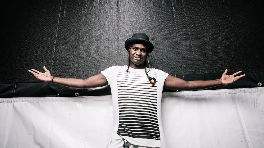 Rapper and dancer Baker Boy arms out in front of a black and white backdrop