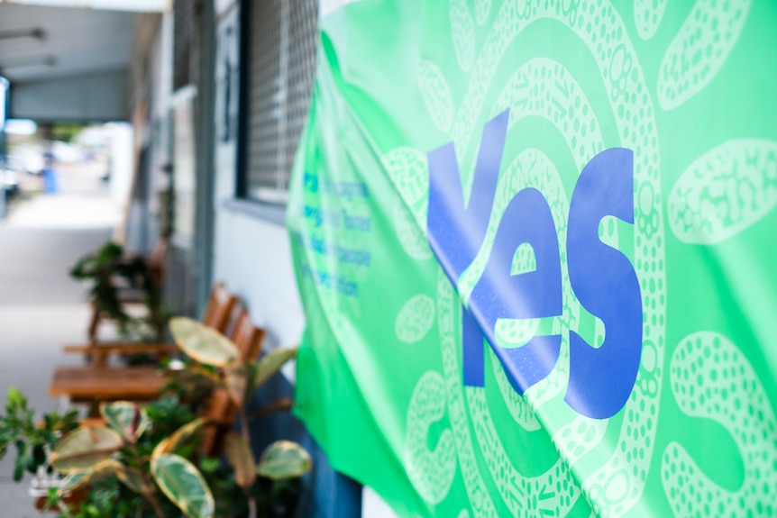 A green and blue banner with the word 'yes' on the front of a cafe
