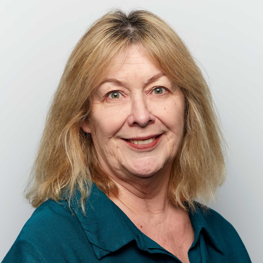 A woman looking at the camera with a smile on her face.