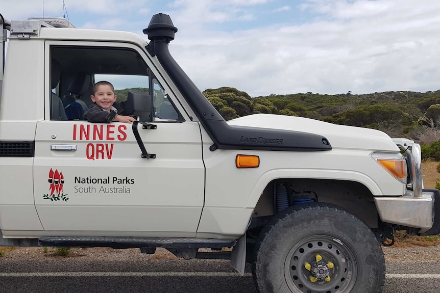 Jake Croker sits in a white park ranger's ute.