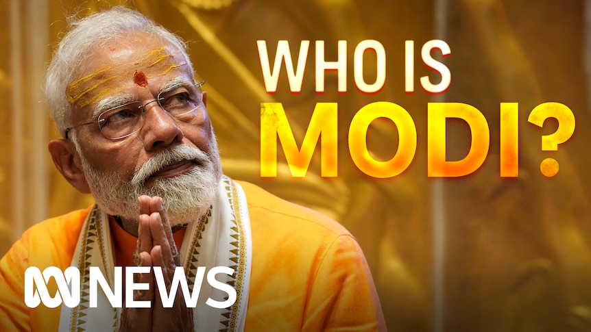 Who is Modi? Narendra Modi looks off-camera with his palms together in front of him.