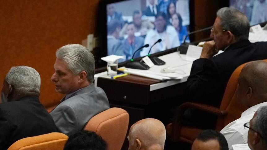 Cuba's President Raul Castro, top right, observes a monitor with his successor Miguel Diaz-Canel sitting nearby.