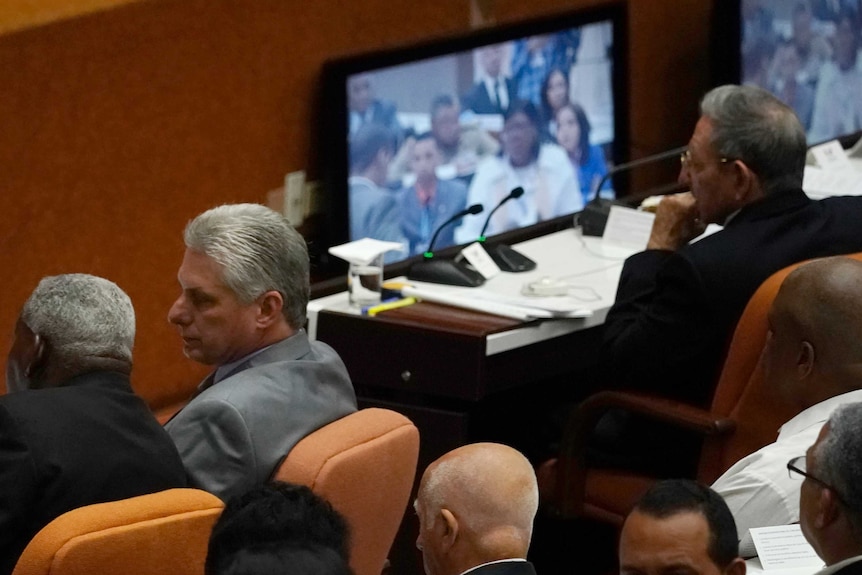 Cuba's President Raul Castro, top right, observes a monitor with his successor Miguel Diaz-Canel sitting nearby.