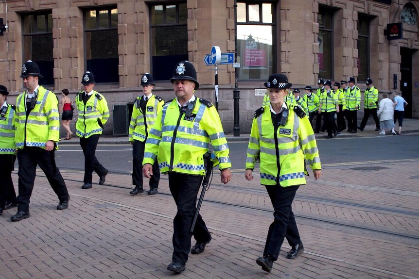 Police walk en masse through the main shopping street of Croydon in south London