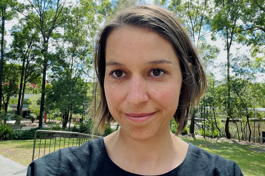 A woman in her 30s, short brown hair, brown eyes, smiling. 