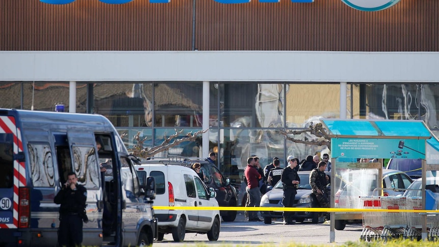 A general view shows gendarmes and police officers at a supermarket.
