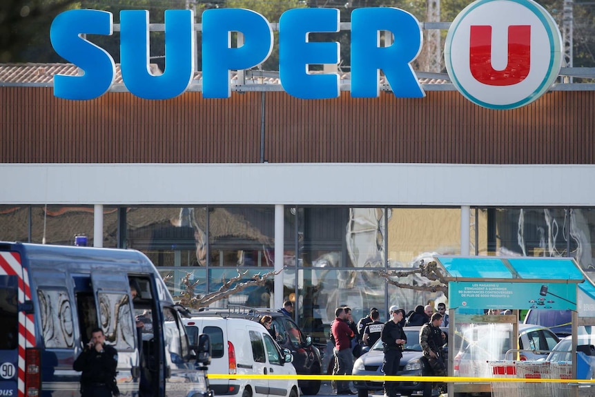 A general view shows gendarmes and police officers at a supermarket.