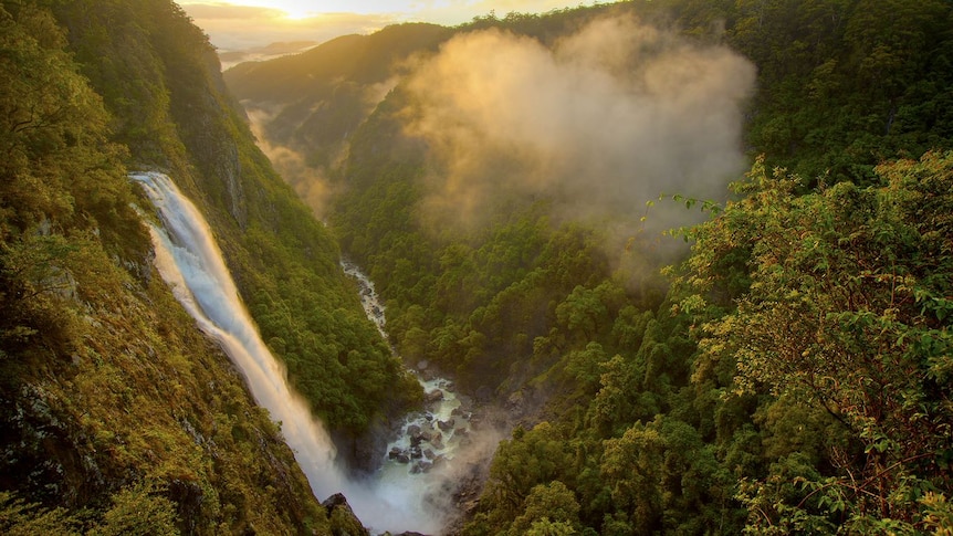 A waterfall cascades down on the left into a river below.