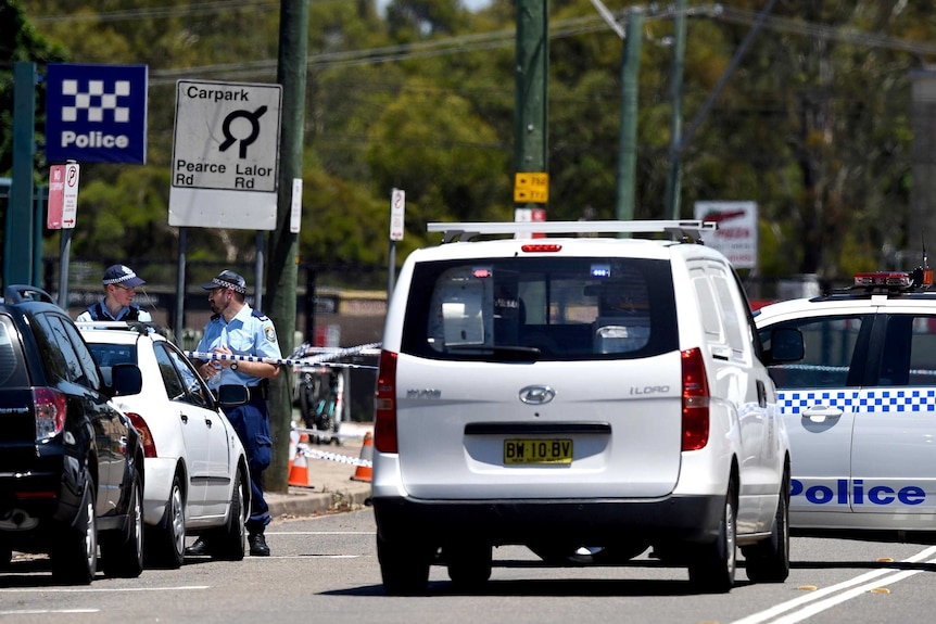 Police officers tape the scene outside the Quakers Hill Police Station.