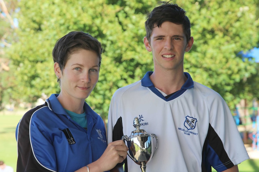 Amanda Williams and Hugh Atkinson holding a cricket trophy.