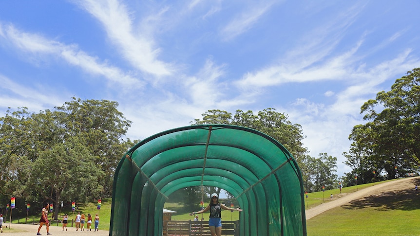 A woman walks through the mist tunnel at Byron Falls Festival