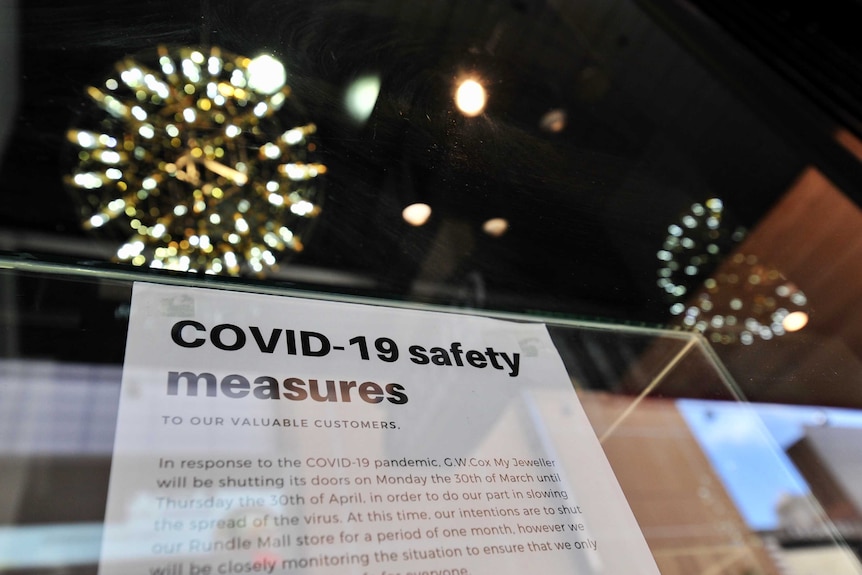 A sign in an Adelaide shop window reads 'COVID-19 safety measures', announcing temporary closure due to coronavirus