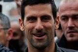 Novak Djokovic looks at the camera while walking among a crowd of people in Montenegro