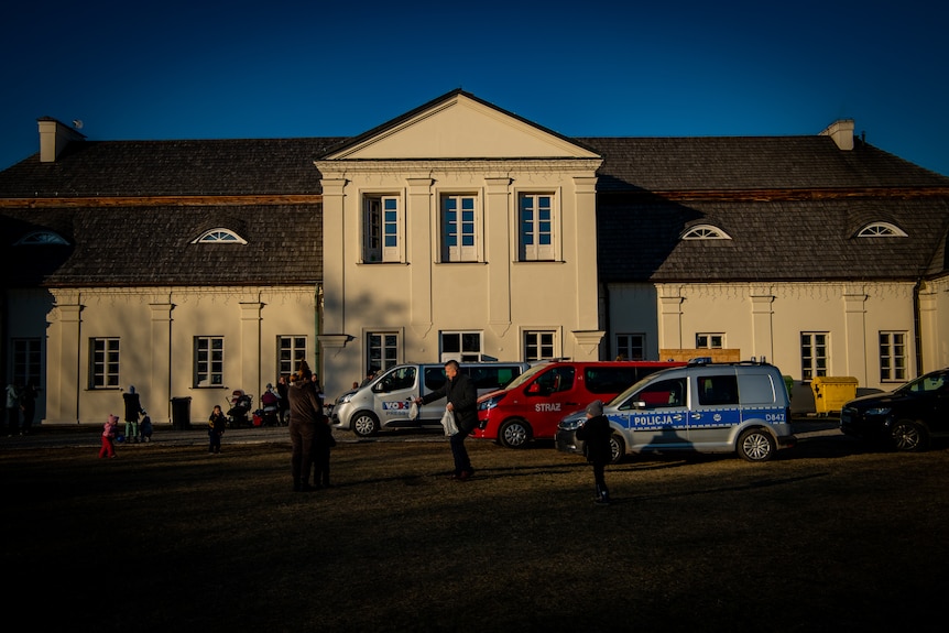 Police vehicles parked outside a stately home, a palace in a small Polish town