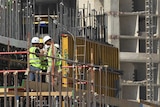 Workers stand on a building construction site in Doha, Qatar.
