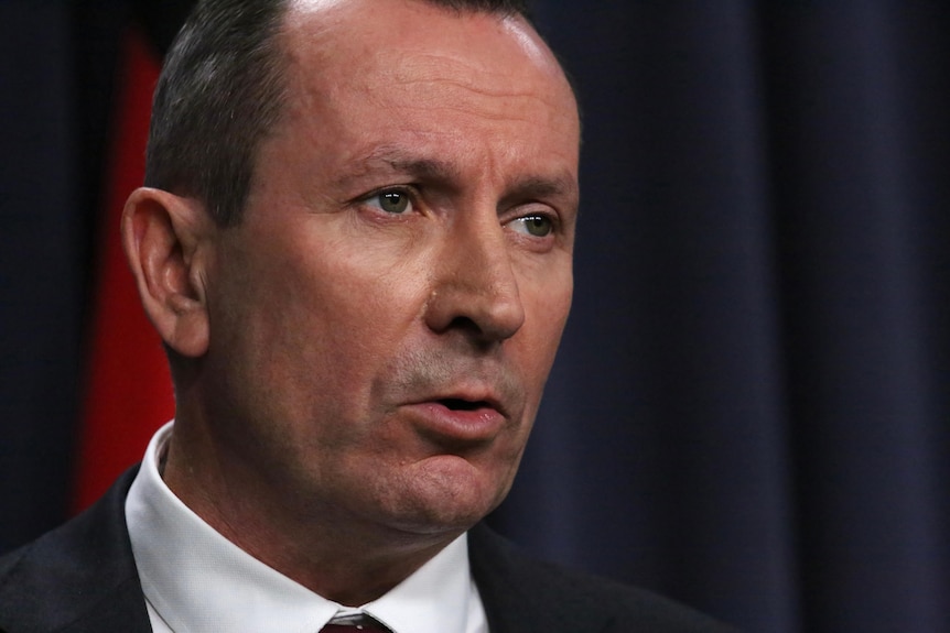 A tight head shot of Mark McGowan speaking indoors at an official government press conference.
