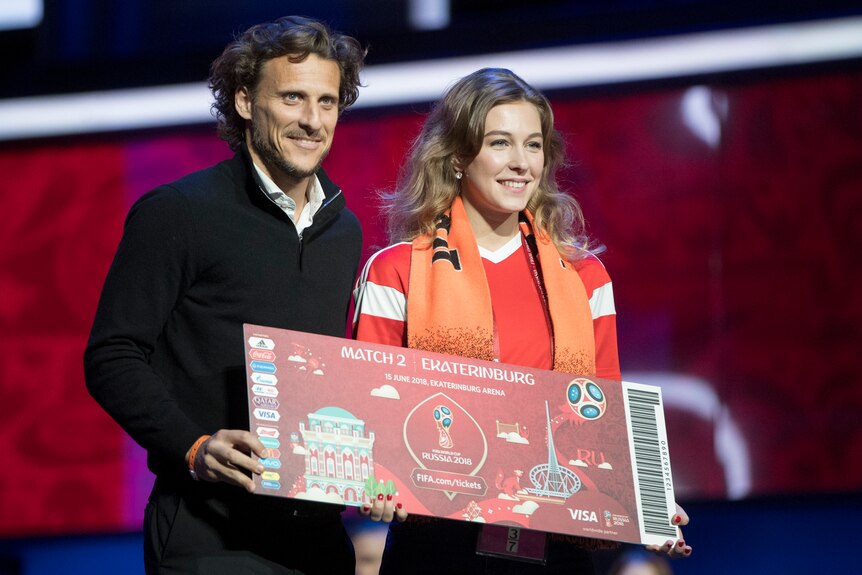 Draw assistant and Uruguayan soccer player Diego Forlan and Ekaterinburg's superfan Maria Panina stand on the stage.