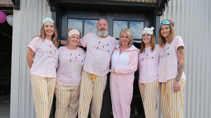 Rex Silver and Linda Woodhead dressed in PJs with the barbers from The Garage Barber Shop