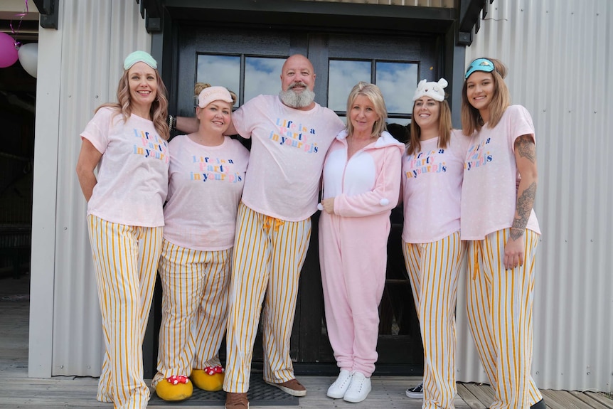 Rex Silver and Linda Woodhead dressed in PJs with the barbers from The Garage Barber Shop