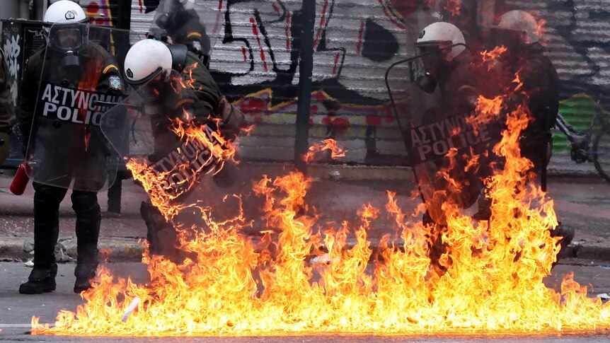 A petrol bomb explodes at riot police during a 48-hour general strike in Athens.