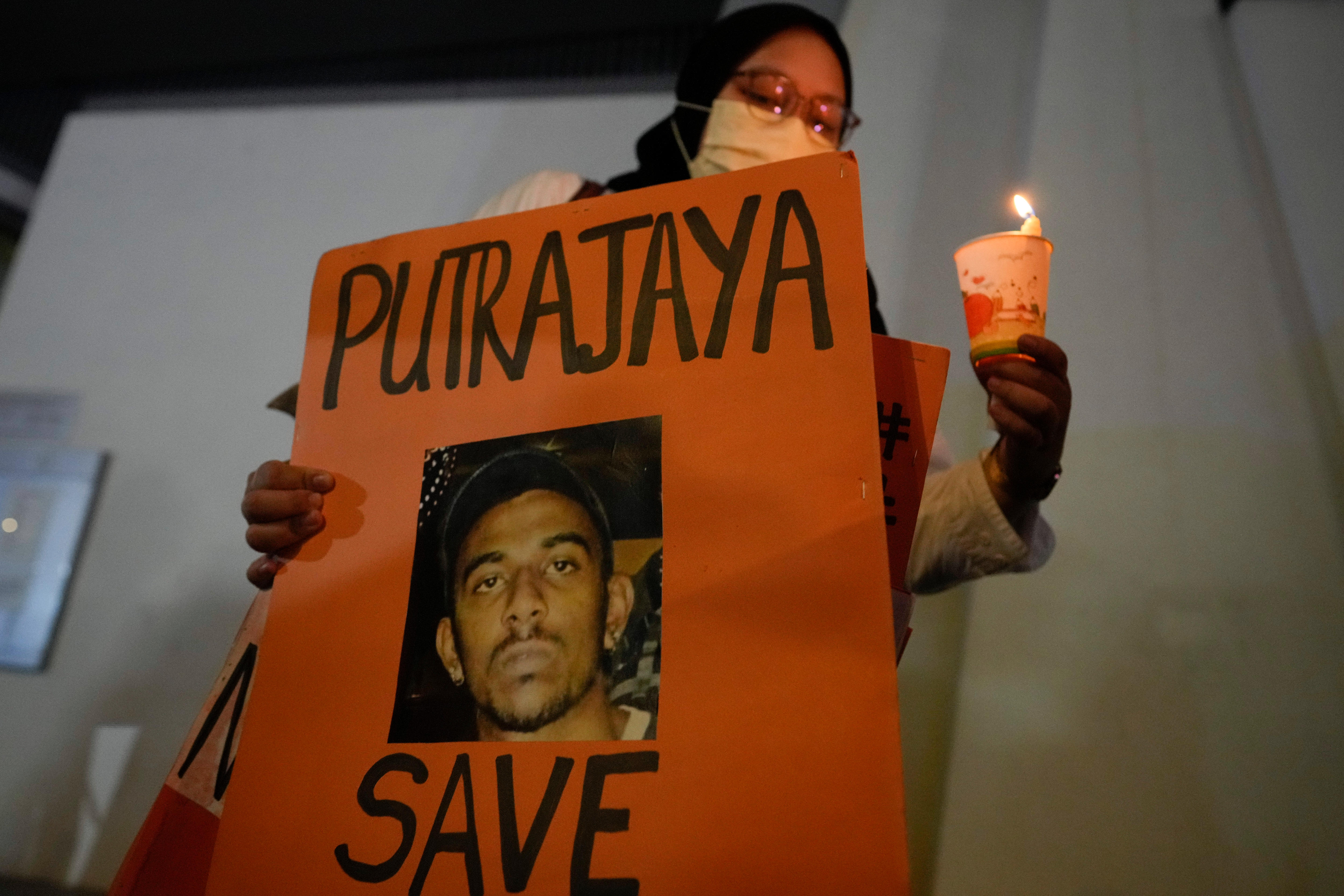 A woman holds a poster in support of Nagaenthran Dharmalingam