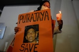A woman holds a poster in support of Nagaenthran Dharmalingam