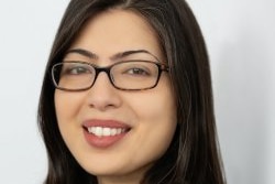 A woman wearing glasses and smiling