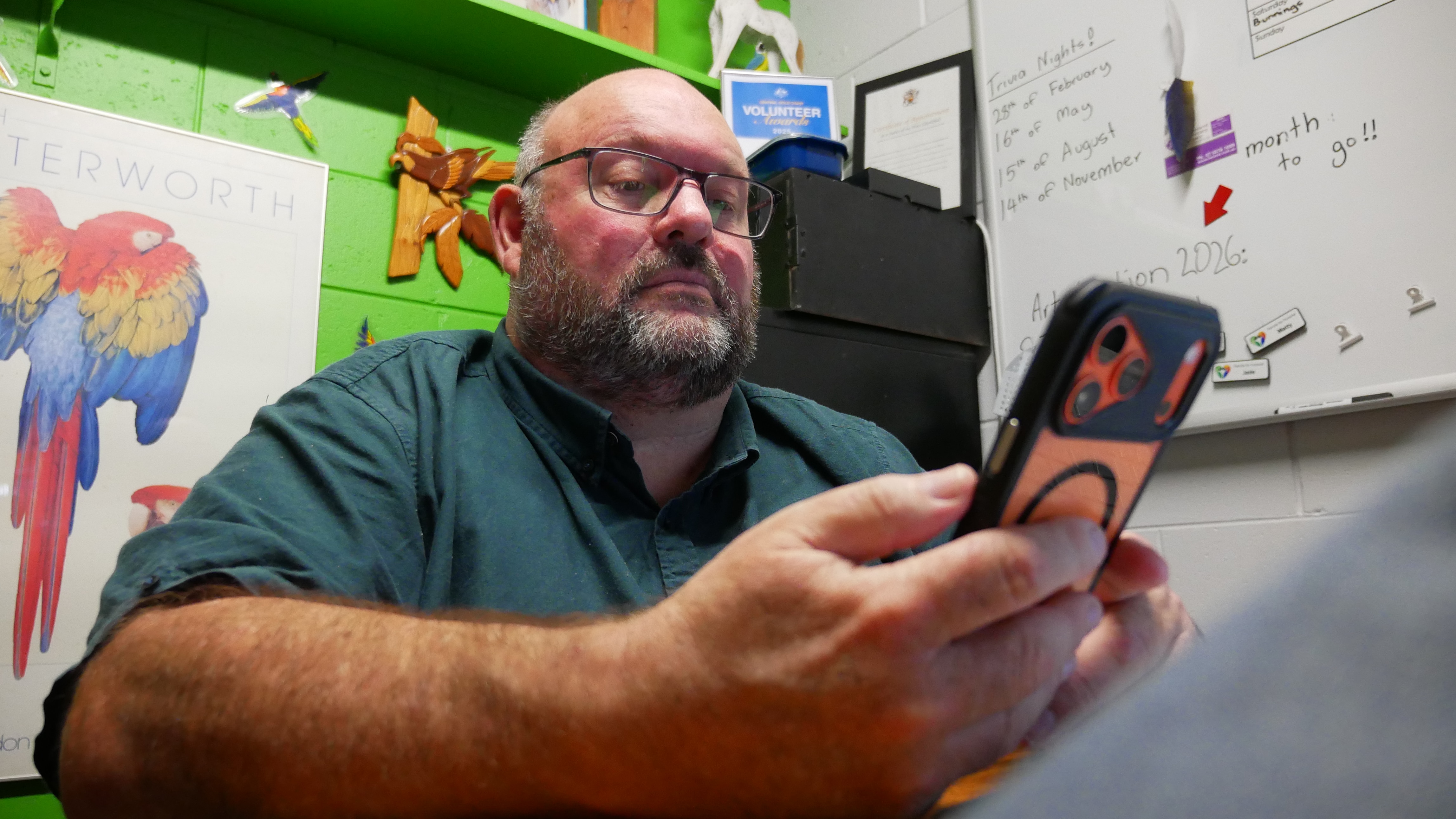 A man holds a phone and looks at it.