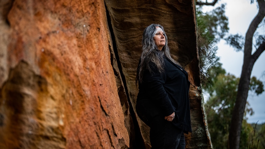 Suellyn Tighe stands beside a rock in the Pilliga forest.