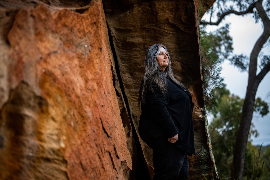 Suellyn Tighe stands beside a rock in the Pilliga forest.