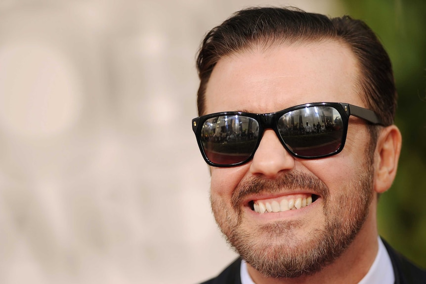 Ricky Gervais arrives at the Golden Globe Awards wearing sunglasses.