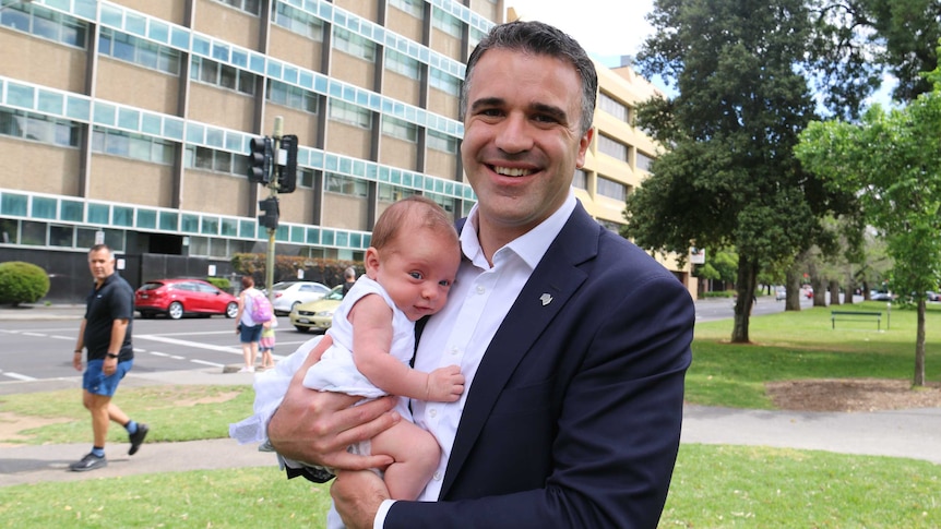 SA Health Minister Peter Malinauskas holds his seven-week-old son.