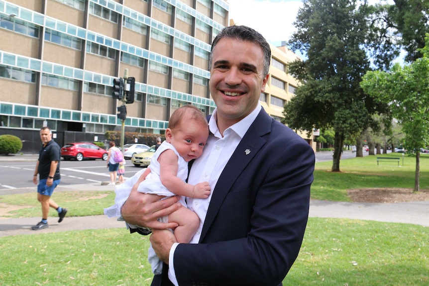 SA Health Minister Peter Malinauskas holds his seven-week-old son.
