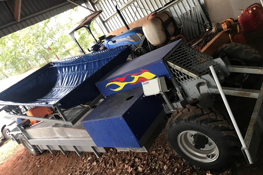 A mobile machine with a large tarpaulin net used to catch and clean picked mangoes.