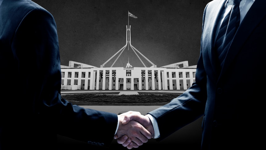 Two men in suits shaking hands, Parliament House and $100 notes in the background. 