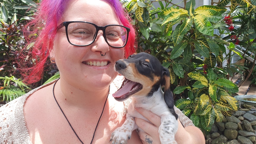lady with pink hair with happy dog with mouth open