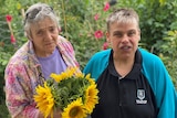 Two ladies standing with flower bouquet 