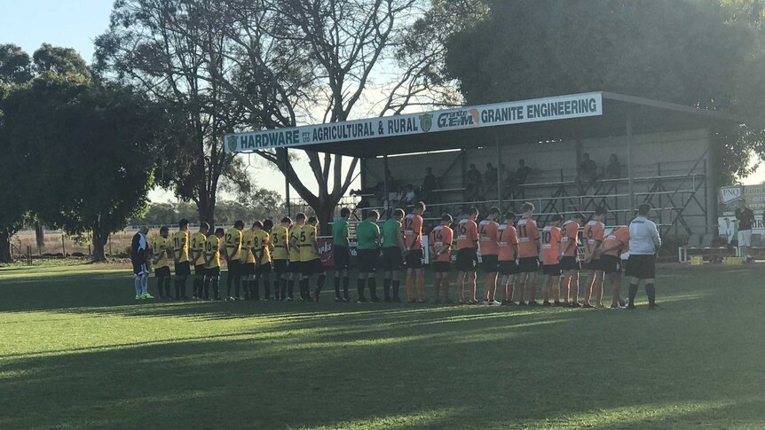 Mareeba United Football Club players observe a minute's silence before a home game in memory of Angus Poggioli.