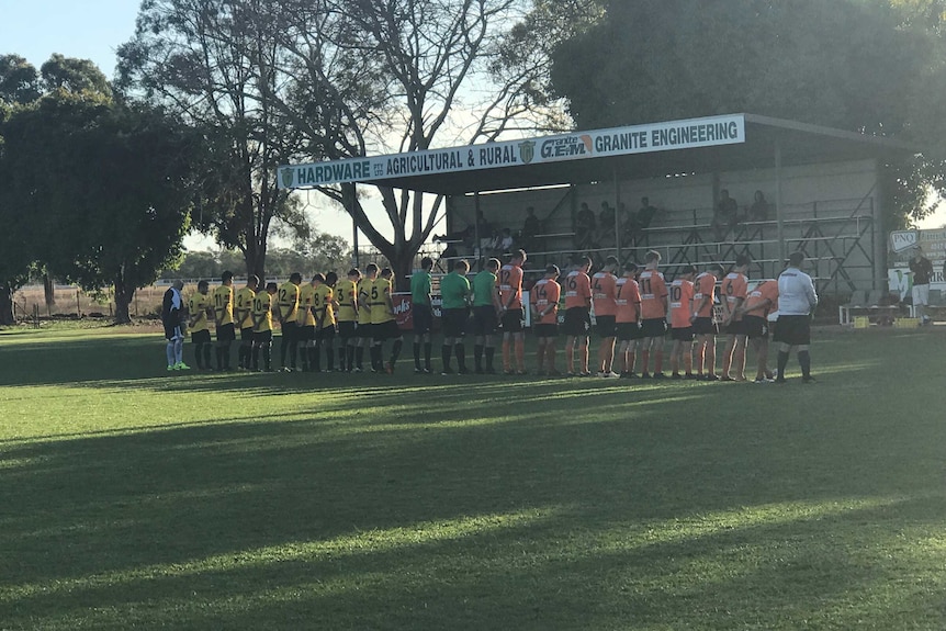 Mareeba United Football Club players observe a minute's silence before a home game in memory of Angus Poggioli.