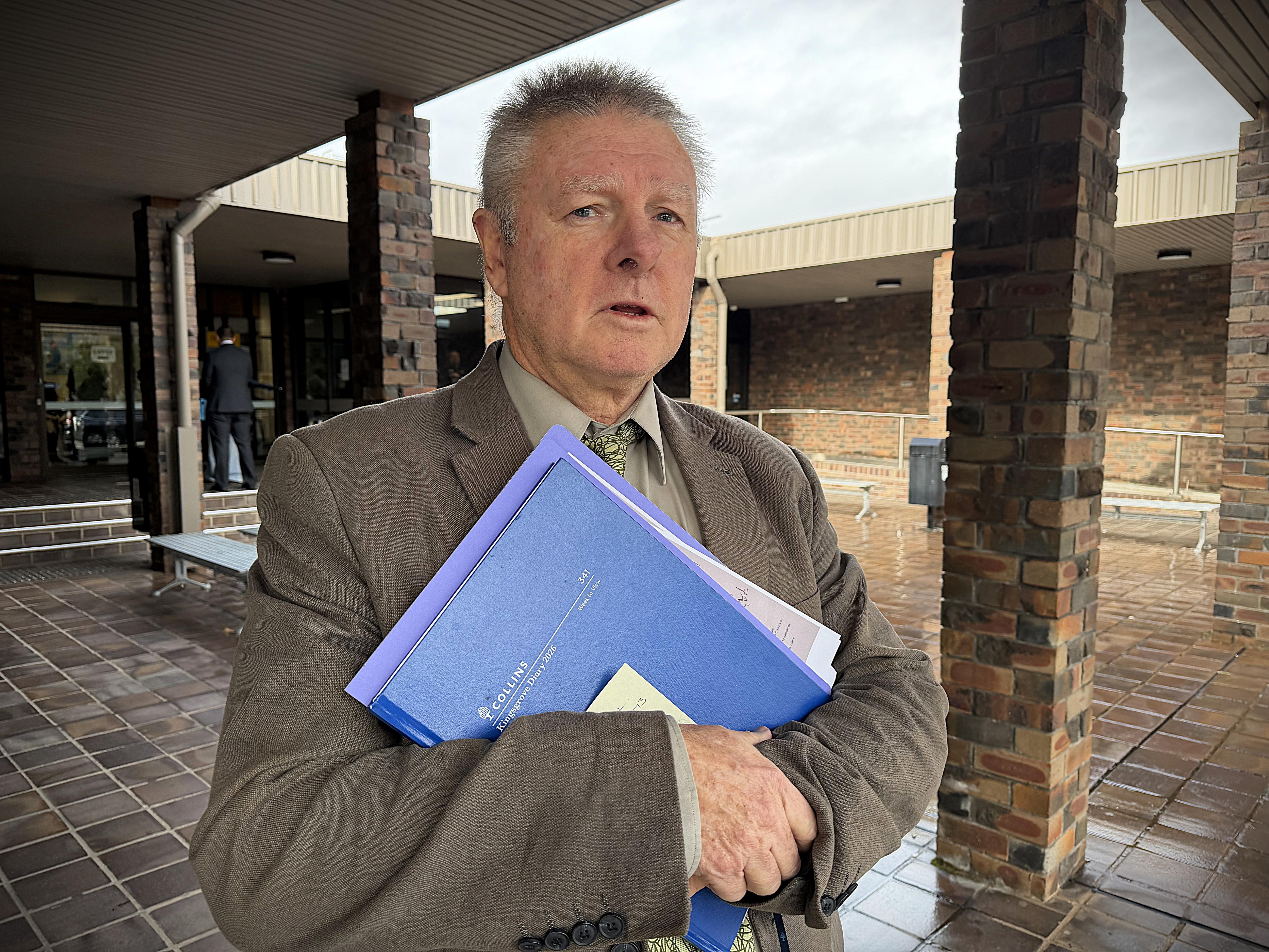Man told purple folder outside brick court house