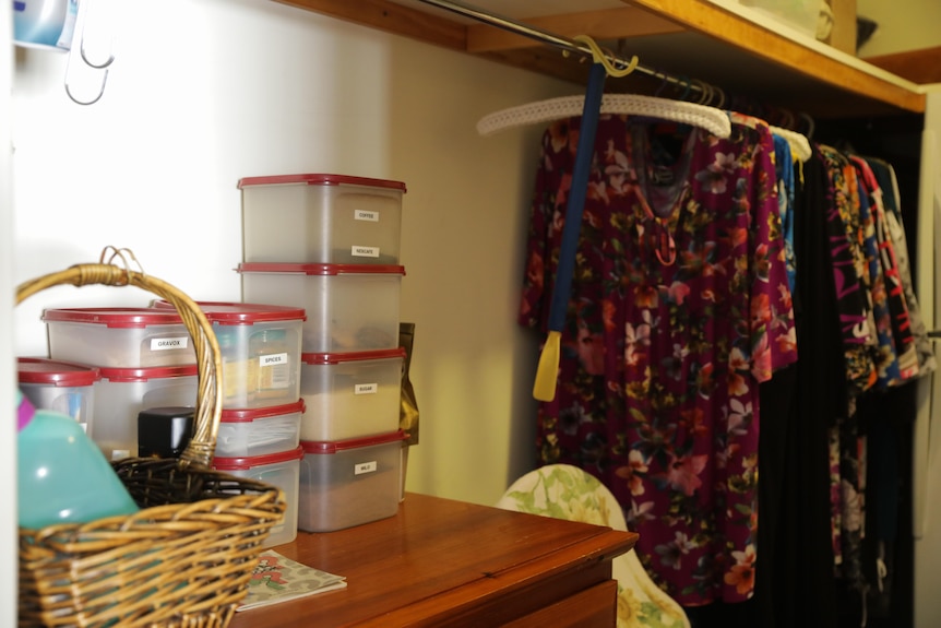 Lisa Dodson's mother's kitchen with kitchen containers on one side and a clothes rack on the other.