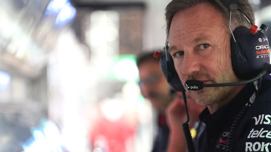 Christian Horner, sitting in the pits, with his head piece on, at the computer.