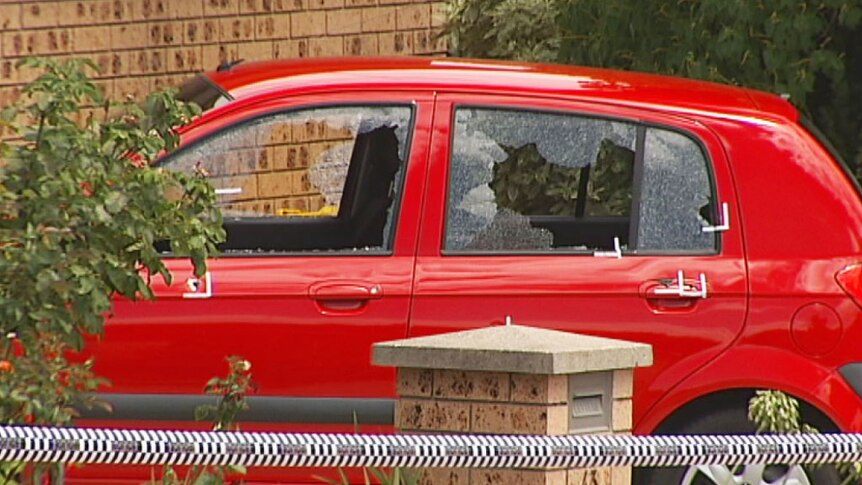 Car with smashed windows and bullet holes