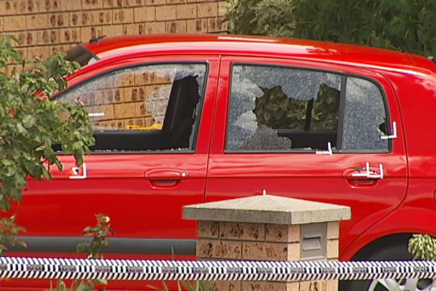 Car with smashed windows and bullet holes