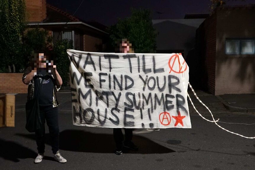 Protesters with a banner outside the home of Melbourne Lord Mayor Robert Doyle.